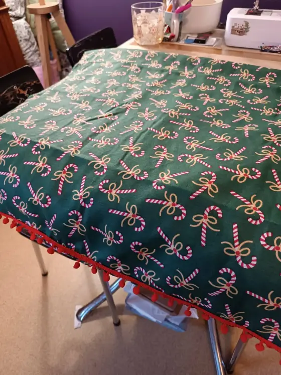 Nappe de Noël verte à motifs sucres d'orge avec pompons rouges
